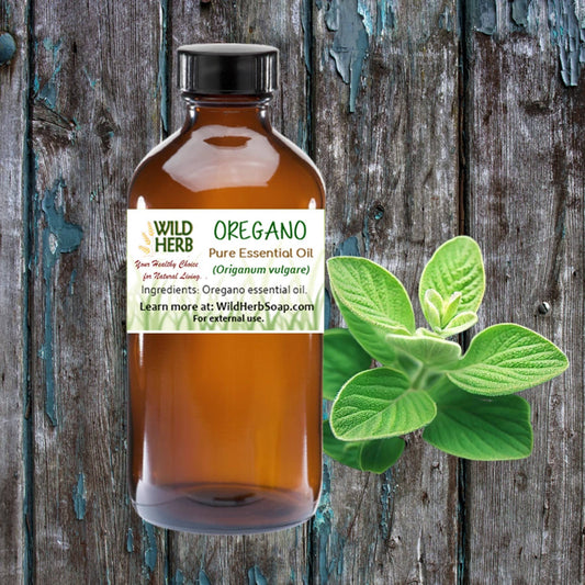 Amber plastic bottle of oregano essential oil with fresh oregano leaves on rustic wooden background