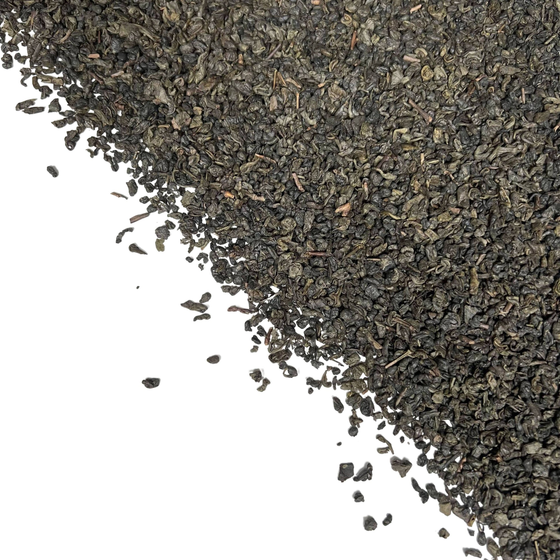 Close-up of dried tightly rolled Gunpowder green tea leaves in bulk on a white background