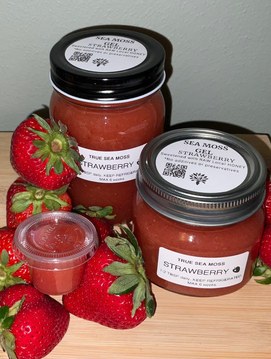Strawberry Sea Moss Gel jars surrounded by fresh strawberries, highlighting the fruit-infused superfood.